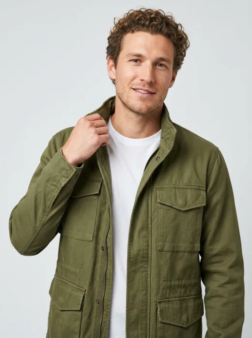 KI-generiertes Shop-Modelbild: Mann in olivgrüner Field Jacket, Halbtotale